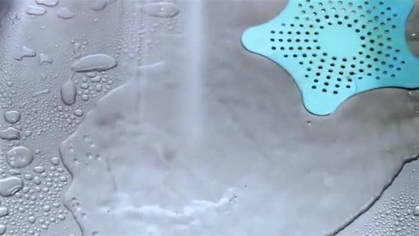 Pływające krople wody z kranu w metalowym zlewie ze stali zbliżenie wideo - Materiał filmowy, wideo