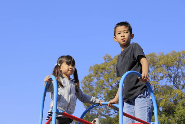 Japán testvér és testvér a kék ég alatt (10 éves fiú és 5 éves lány) - Fotó, kép