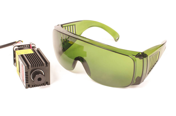 Safety green glasses for protection from laser radiation and high power laser isolated on the white background - Photo, Image