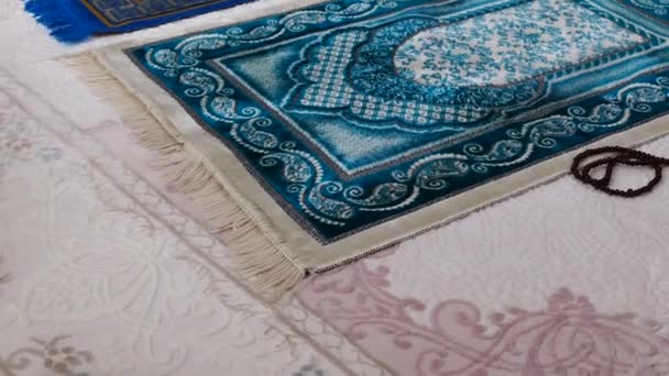 Simboli islamici, tappeti di preghiera blu e verdi su un tappeto in una casa
, - Filmati, video