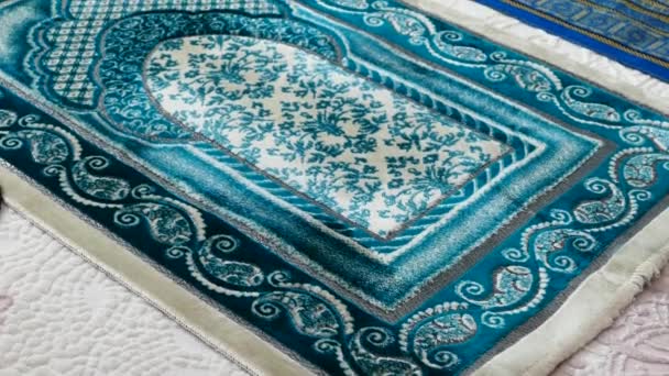 Simboli islamici, tappeti di preghiera blu e verdi su un tappeto in una casa
, - Filmati, video