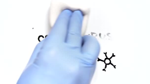 Concepto final de la epidemia. Una mano en un guante médico borra la palabra CORONAVIRYS
 - Imágenes, Vídeo