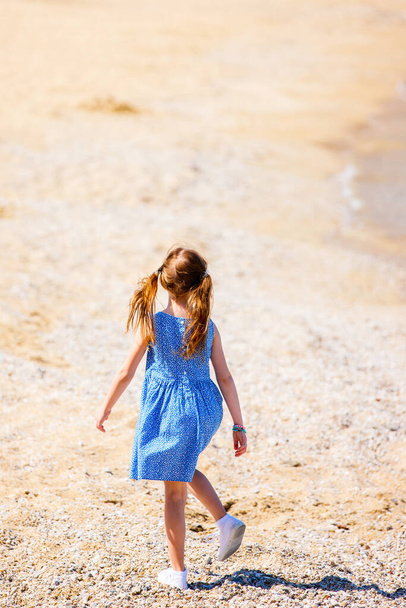 Back view of a little girl at beach during summer vacation - 写真・画像