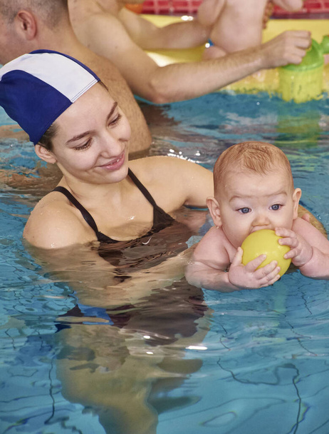 Italien, junge Mutter und ihr neugeborenes männliches Kind in einem Schwimmbad - Foto, Bild