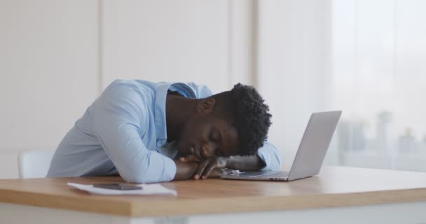 Joven africano durmiendo en el teclado portátil en casa oficina
 - Imágenes, Vídeo