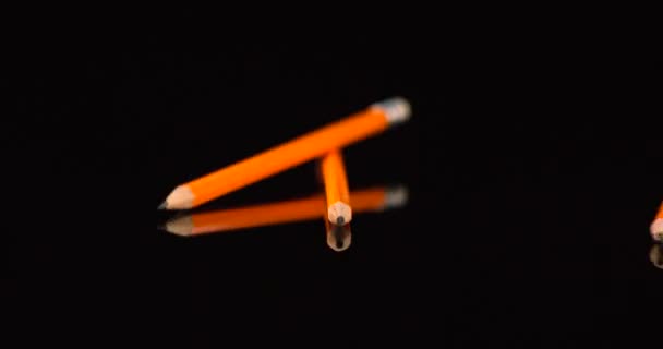 黄色の学校の鉛筆はゆっくりと動きに落ちる。黒の背景に隔離されたペンシルドロップ. - 映像、動画