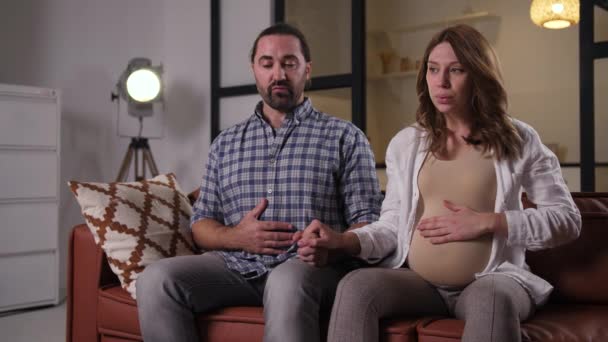 Έγκυος ζευγάρι κάνει άσκηση αναπνοής στον καναπέ - Πλάνα, βίντεο