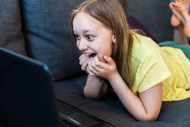 Happy excited preteen girl chatting online using laptop for video call. - Φωτογραφία, εικόνα