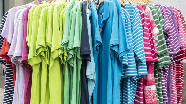 Κατάστημα προσφέρει πολύχρωμα ρούχα μπροστά από ένα κατάστημα - Φωτογραφία, εικόνα