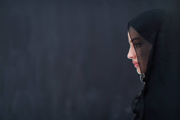 portrait of beautiful muslim woman in fashionable dress with hijab in front of black chalkboard representing modern islam fashion and ramadan kareem concept - Foto, Bild