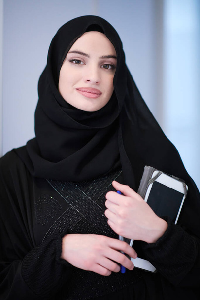 młody nowoczesny muzułmanin biznes kobieta gospodarstwa tablet noszenie hidżab ubrania w domu - Zdjęcie, obraz