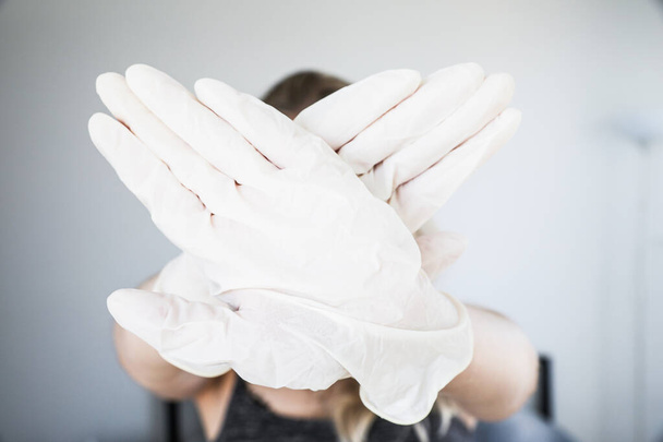 Crossed hands wearing protective white gloves - Photo, Image