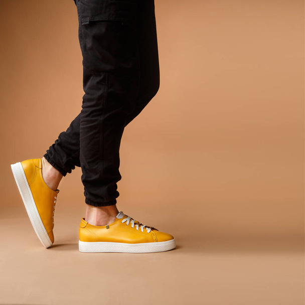 Zapatos casuales amarillos de los hombres sobre fondo marrón
 - Foto, Imagen