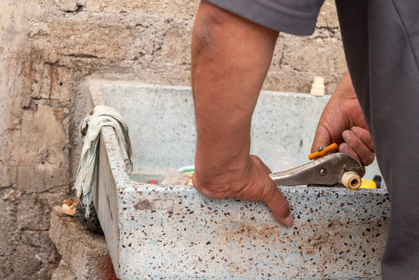 egy férfi kezei, aki megjavítja a saját háza csövét. - Fotó, kép