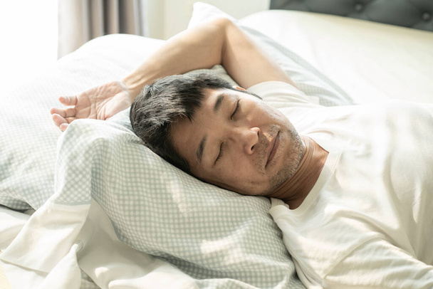 Senior asiam man slapen op het bed - Foto, afbeelding