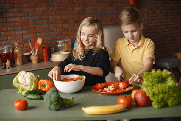 Children prepare salan in a kitchen - Foto, afbeelding