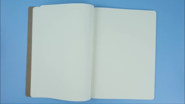 Avaa kirjan valkoinen sivu Tyhjä tekstin ja tekstitysten lisäämiseksi sinisellä pohjalla
. - Materiaali, video