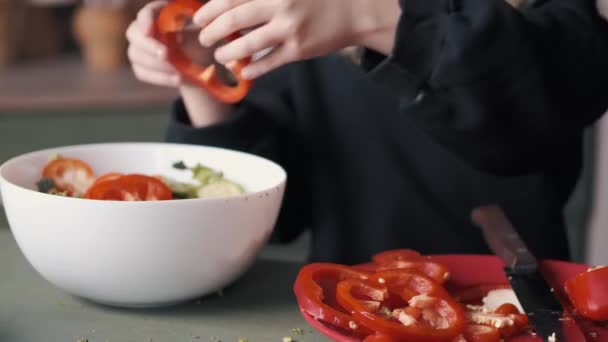 Pequeña niña está haciendo una ensalada de verduras frescas
 - Metraje, vídeo
