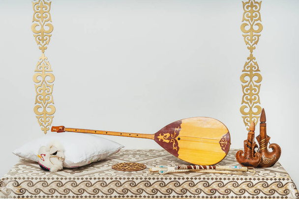Dombra nationale kazakhe instrument de musique sur fond blanc. Décor national kazakh ornements en or et articles ménagers. Kazakh kirghize origine ethnique
 - Photo, image