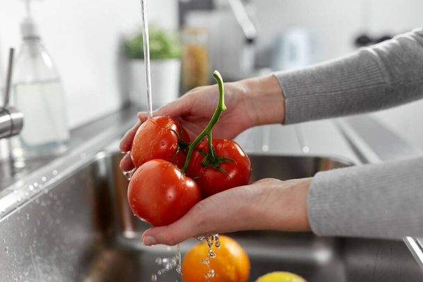 woman washing fruits and vegetables in kitchen - Foto, Imagen