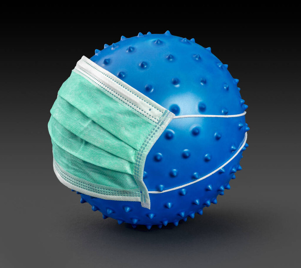εικόνα ενός συμβόλου μπλε ιού φορώντας μάσκα προσώπου σε σκοτεινή πλάτη - Φωτογραφία, εικόνα