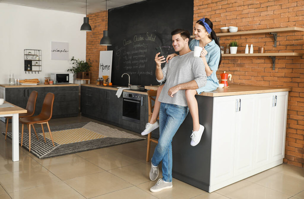 Happy young couple with mobile phone at home - Photo, Image