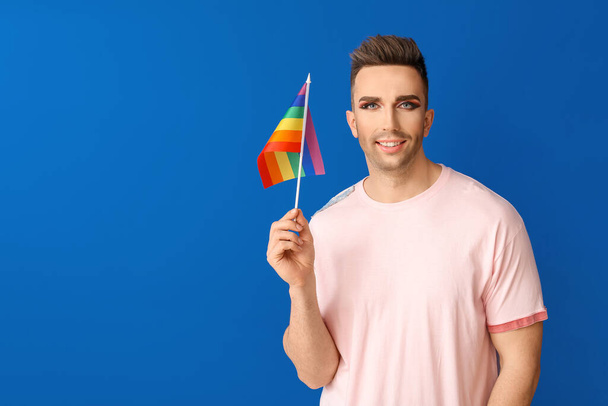 Retrato de mujer transgénero joven con bandera de LGBT sobre fondo de color
 - Foto, imagen