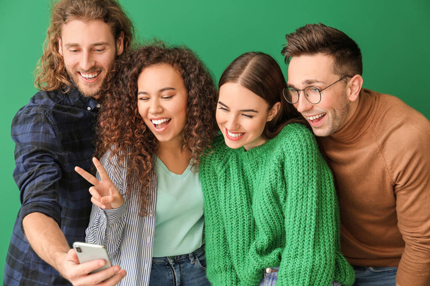 Friends taking selfie on color background - Photo, Image