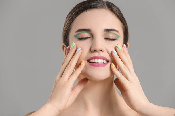 Young woman with beautiful manicure on grey background - Foto, immagini