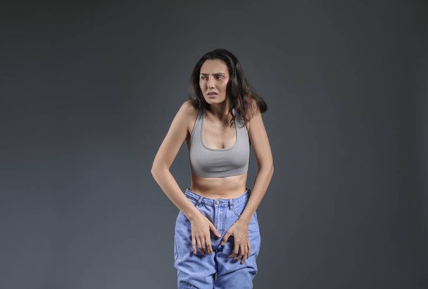 Mujer joven con anorexia sobre fondo gris
 - Foto, imagen