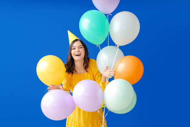 Hermosa mujer joven celebrando el cumpleaños en el fondo de color
 - Foto, Imagen