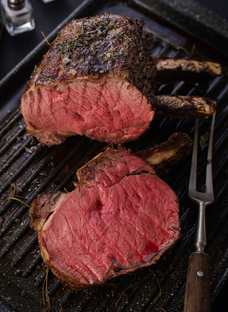 Grillezett húsdarab csonttal egy grillsütőben. Sült steak. Pirítás - Közepes ritkaság. - Fotó, kép
