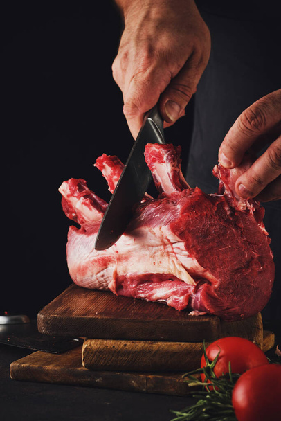 Male butcher cuts raw beef meat - Valokuva, kuva