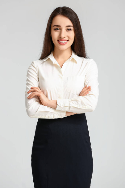 Portrait of beautiful young businesswoman on light background - Photo, Image