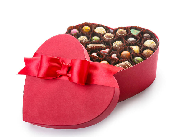 Herzförmige Schachtel mit leckeren Bonbons auf weißem Hintergrund - Foto, Bild