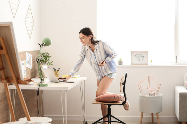 Young female designer working at home - Foto, imagen