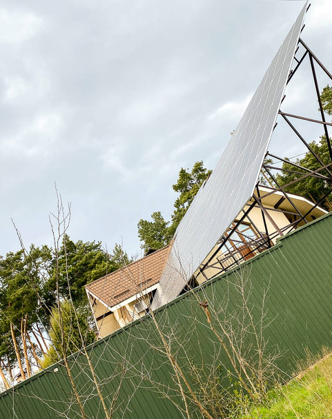 Ηλιακοί συλλέκτες τοποθετημένοι στην οροφή ενός μεγάλου σπιτιού. - Φωτογραφία, εικόνα