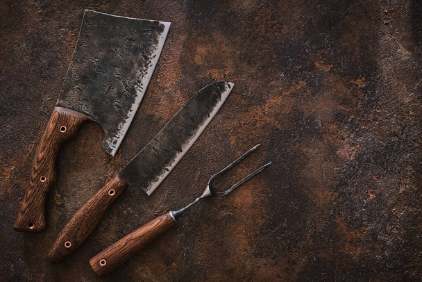 Elegante conjunto de carnicero: cuchilla, cuchillo y tenedor. Vista superior
. - Foto, imagen