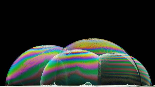 iridescenza sulla superficie di alcune bolle di sapone illuminate dal basso
 - Foto, immagini