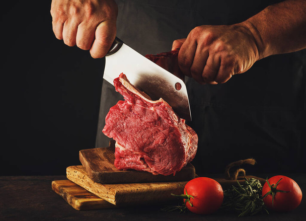 Чоловічий м'ясник нарізає сире м'ясо яловичини
 - Фото, зображення
