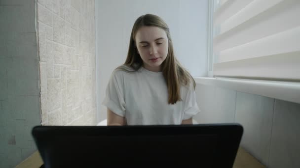 Счастливая женщина работает ноутбук компьютер на кухне. Счастливый человек использует компьютерные технологии дома
. - Кадры, видео