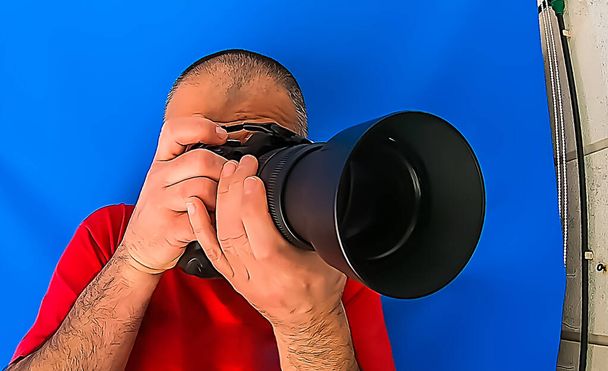 Άνδρας με κόκκινο πουκάμισο και κάμερα σε δράση - Φωτογραφία, εικόνα