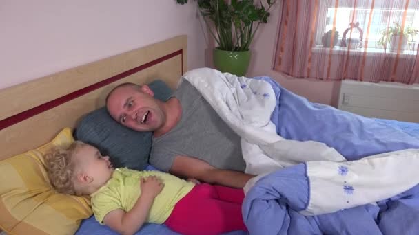 Baba ve kızı renkli yatağın altına saklanıyorlar. 4K - Video, Çekim