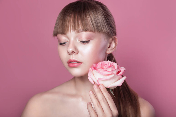 Beautiful woman with natural make-up holding rose. on pink background - Fotografie, Obrázek