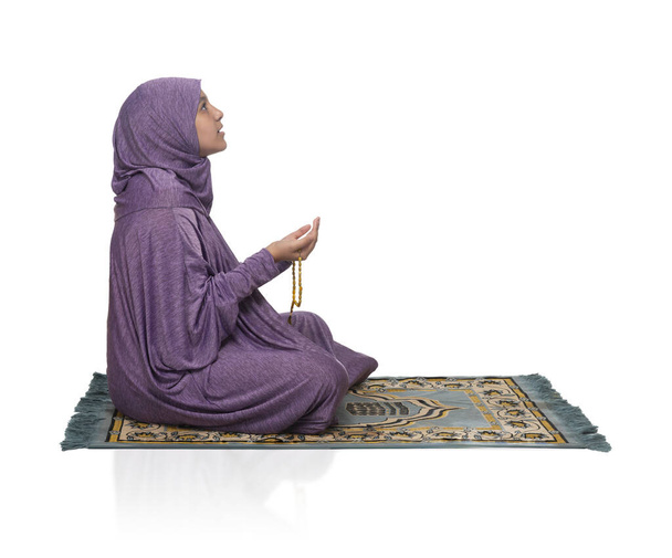 Schöne arabische Mädchen, die für Allah beten, tragen muslimische Kleidung isoliert auf weißem Hintergrund - Foto, Bild