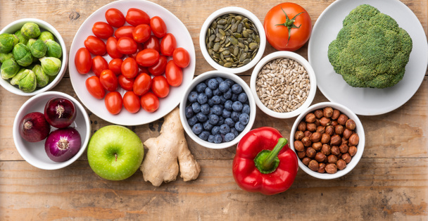 Zdrowe składniki odżywcze: świeże warzywa, owoce i superjedzenie. Odżywianie, dieta, wegańska koncepcja żywności. Kontekst drewniany - Zdjęcie, obraz