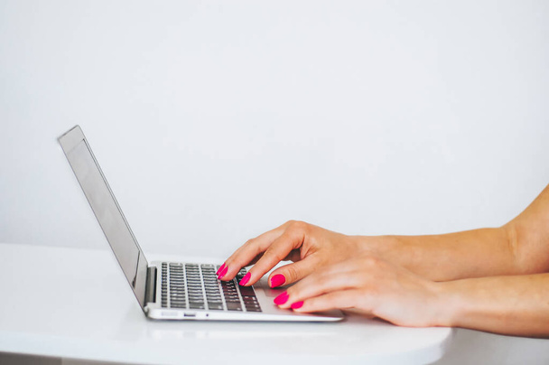 Kobiece ręce pracujące nad nowoczesnym laptopem. Widok z bliska okularów na notatniku i osoby korzystającej z laptopa za. - Zdjęcie, obraz