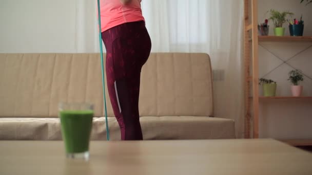 Vaso de batido verde con mujer borrosa tratando de perder peso sobre el fondo
 - Metraje, vídeo
