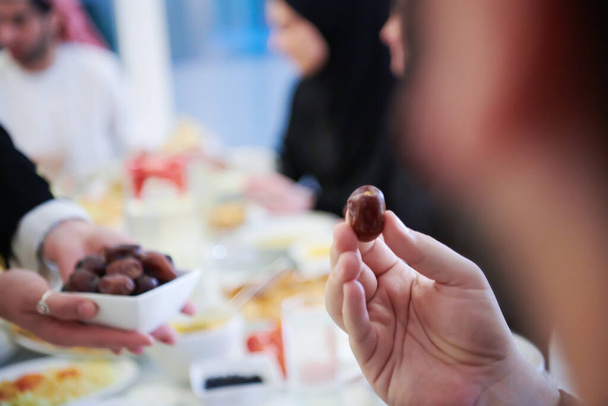 Eid Mubarak Muslim family having Iftar dinner eating dates to break feast. Eating traditional food during Ramadan feasting month at home. The Islamic Halal Eating and Drinking at modern western Islam - Fotó, kép