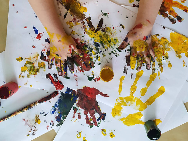 子供の手は絵のための塗料で染色されます。創造性、子供時代、レジャー、ドローイングの概念 - 写真・画像